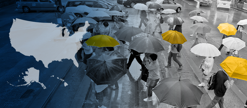 A person stands with their back to the camera, carrying a bright yellow umbrella in the middle of a storm. They stand on a pier, looking out at the stormy sky, which simultaneously looks threatening and hopeful as some of the clouds part to reveal a glimpse of sunshine.